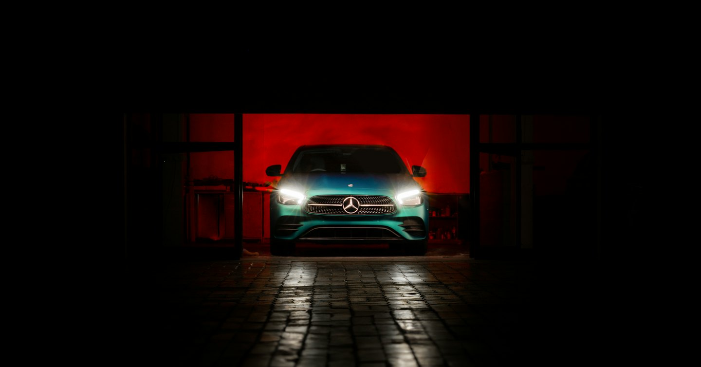 Sinakasroheline Mercedes-Benz esituled põlemas, sõitmas märjale tänavale.